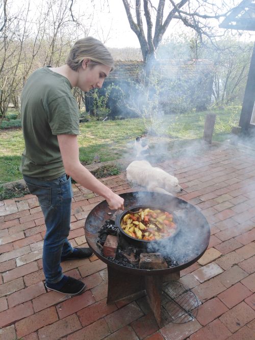 Nol cooking a peka on an open fire